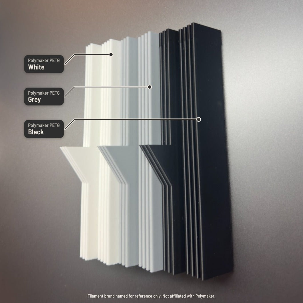 3D-printed material samples on Middle Channel Lower, labelled Polymaker PETG White, Grey and Black. Filament brand named for reference only; not affiliated with Polymaker.